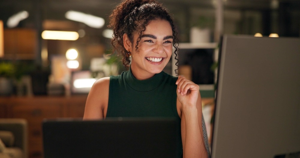  A smiling HR professional works confidently at her desk, reflecting the positive workplace culture an EAP helps support