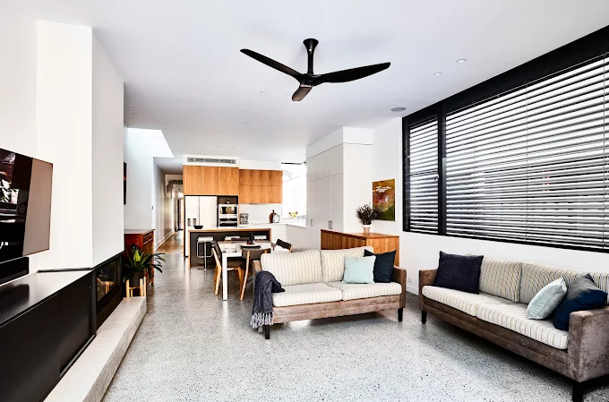 Living room with a seamless polished concrete floor finish, showcasing a durable, low-maintenance flooring solution for modern homes